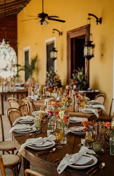 Mesas adornadas con flores y cubiertos para uuna boda